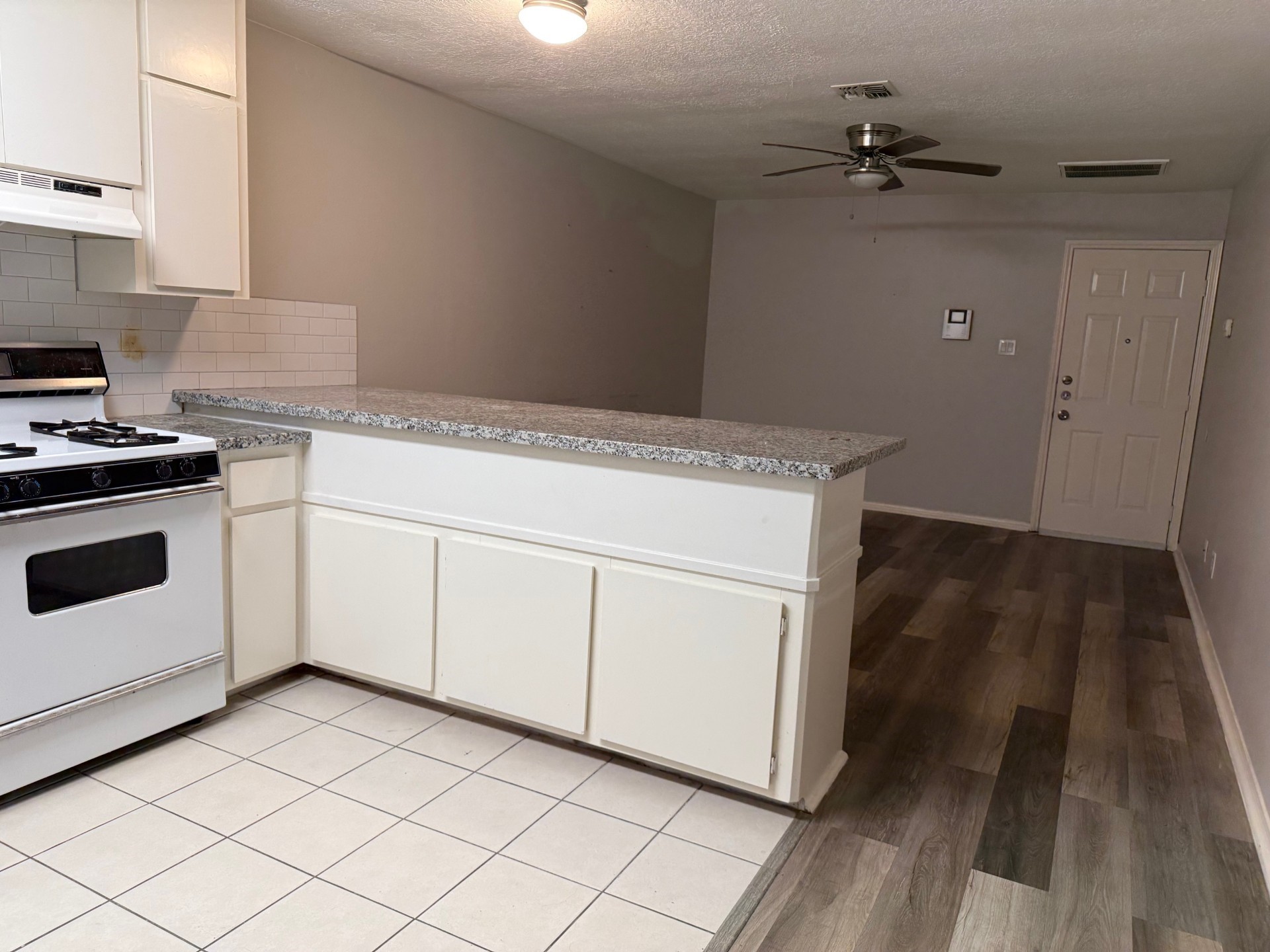 400 West Texas Avenue, Unit 2 Baytown, TX 77520 - Photo 4 of 12 a kitchen with a stove and white cabinets
