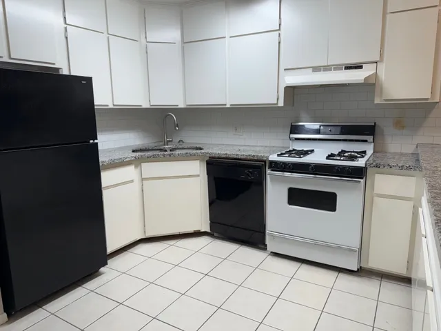 a kitchen with a stove top oven and cabinets