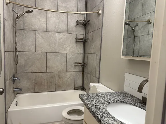 a bathroom with a granite countertop sink and shower