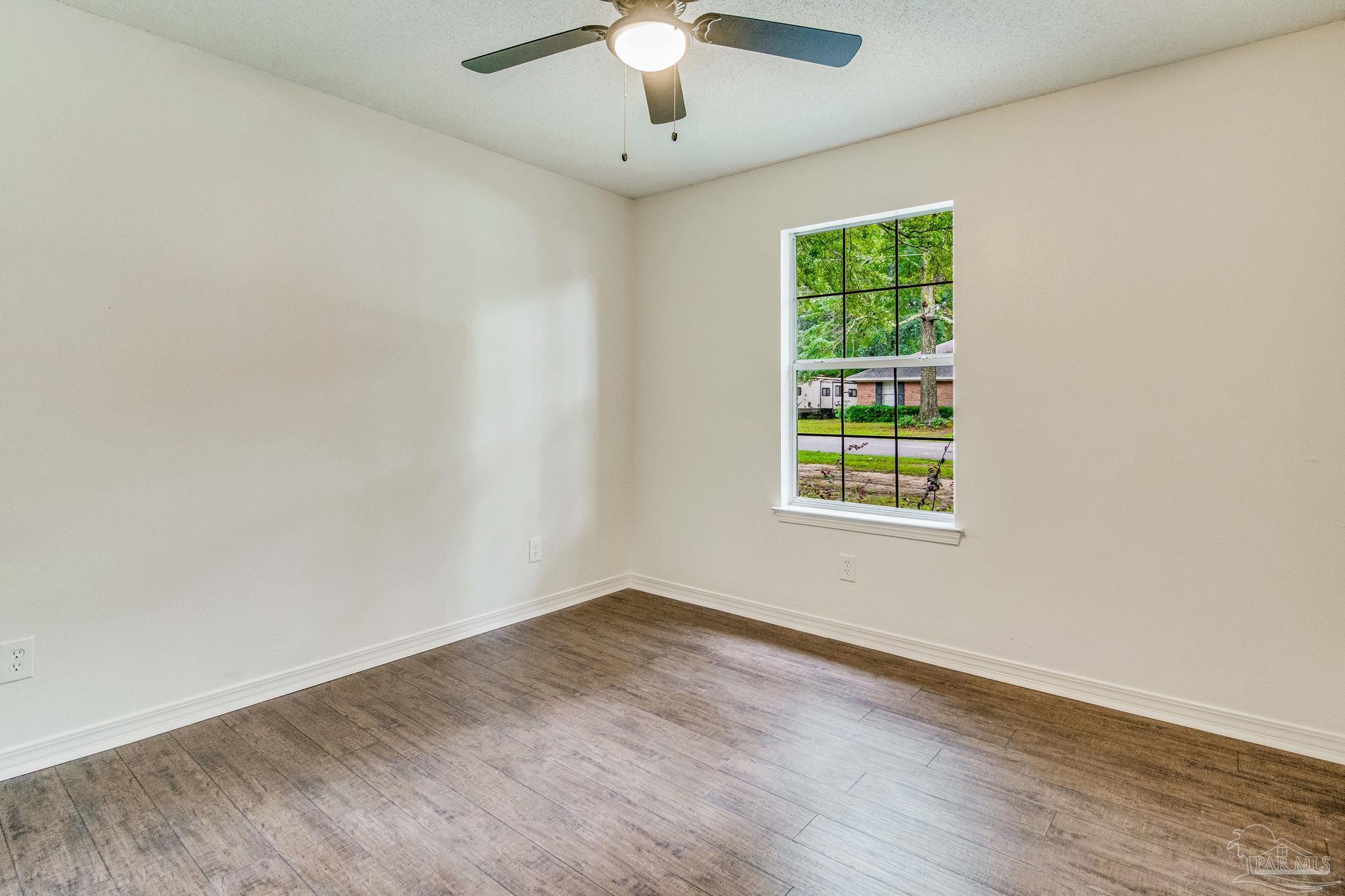 4737 Frontier Road Pace, FL 32571 - Photo 23 of 32 wooden floor in an empty room with a window