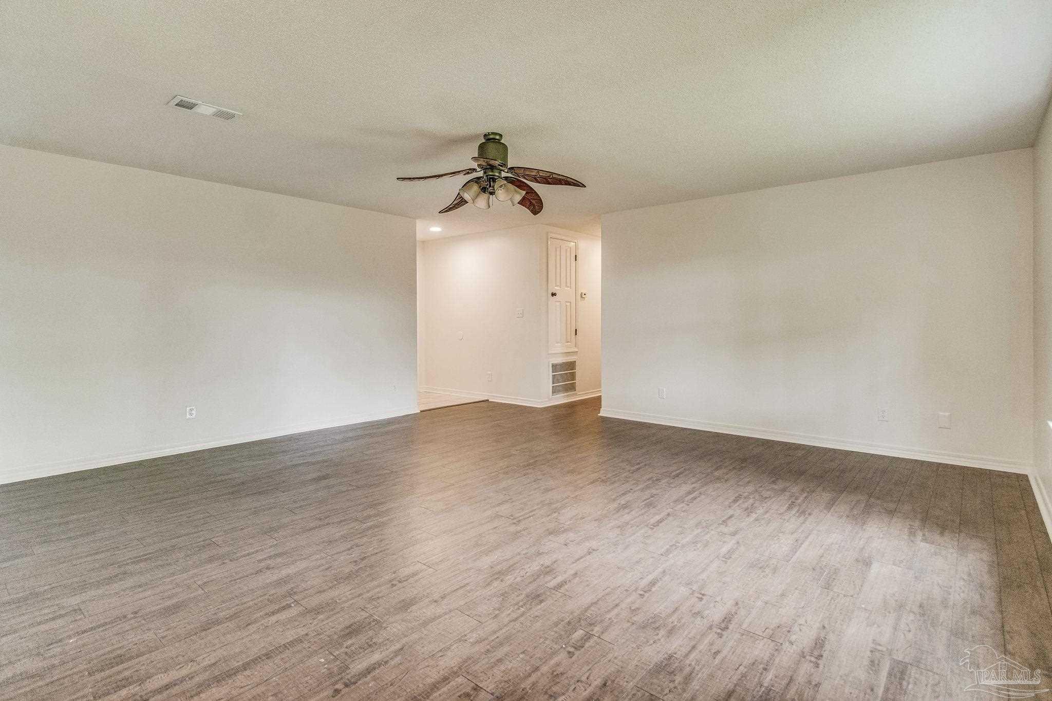 4737 Frontier Road Pace, FL 32571 - Photo 5 of 32 a view of a room with wooden floor and ceiling fan