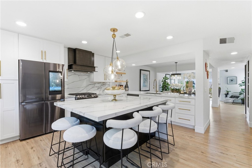 23281 Atlantis Way Dana Point, CA 92629 - Photo 20 of 81 a kitchen with stainless steel appliances a dining table chairs refrigerator and stove