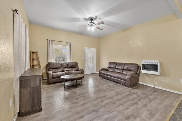 a living room with furniture and a large mirror next to a window
