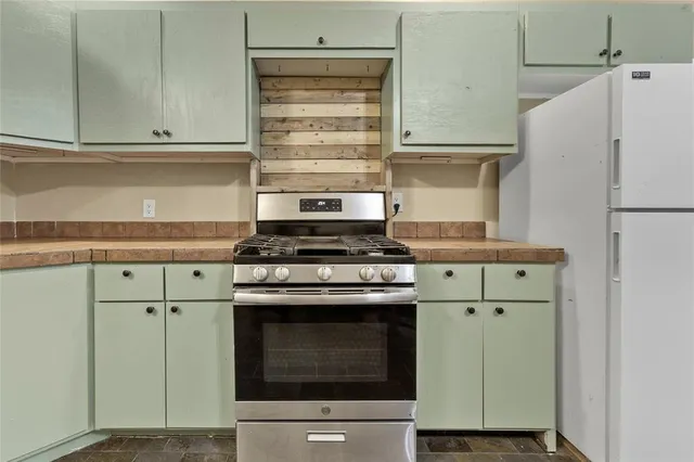 a kitchen with a dining table chairs and stainless steel appliances