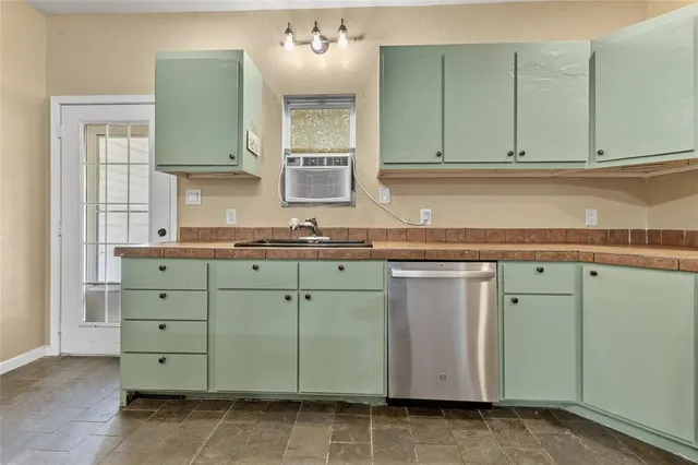 a kitchen with granite countertop cabinets appliances and a counter space