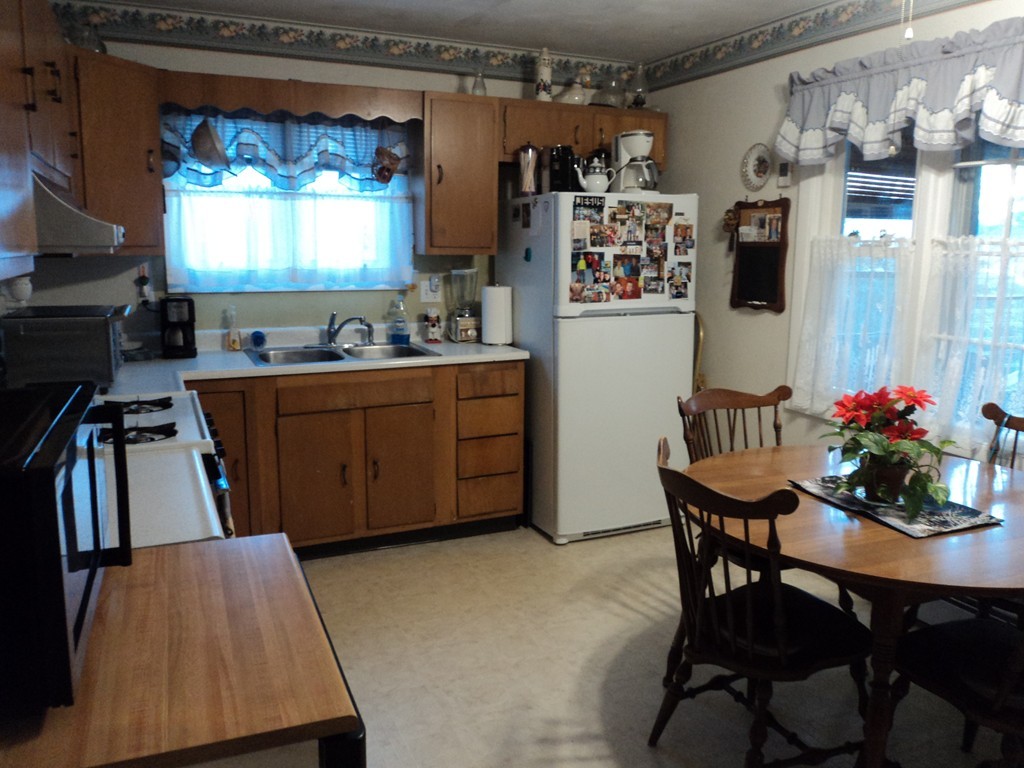 36 Longview Road New Bedford, MA 02745 - Photo 8 of 12 a kitchen with stainless steel appliances kitchen island granite countertop a table chairs in it and a window