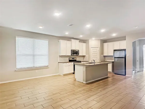 a kitchen with stainless steel appliances granite countertop a refrigerator sink and cabinets