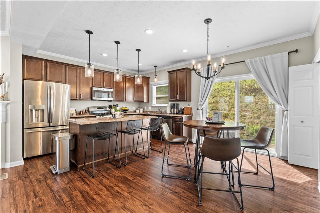159 Rylie Drive Harmony, PA 16037 - Photo 11 of 36 a kitchen with stainless steel appliances granite countertop a refrigerator a stove a sink dishwasher and a dining table with wooden floor