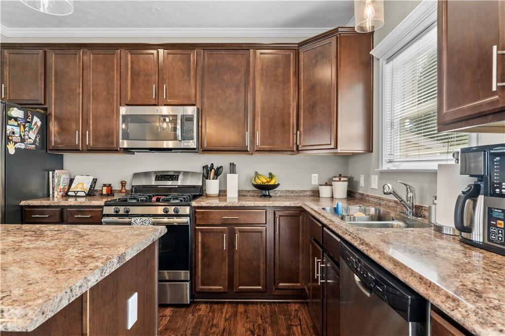 159 Rylie Drive Harmony, PA 16037 - Photo 15 of 36 a kitchen with stainless steel appliances granite countertop a stove a sink dishwasher and cabinets with wooden floor