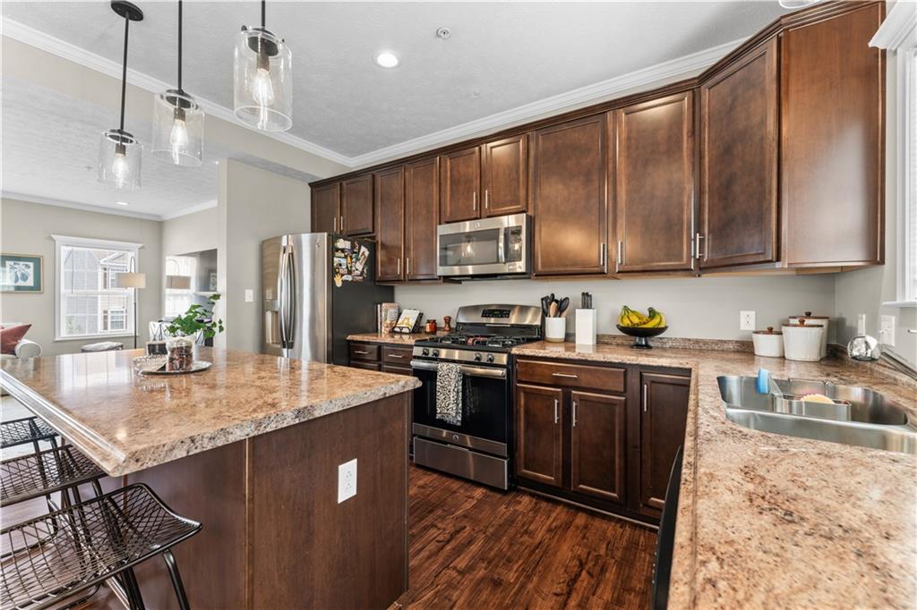 159 Rylie Drive Harmony, PA 16037 - Photo 17 of 36 a kitchen with stainless steel appliances granite countertop a refrigerator a stove a sink dishwasher and wooden cabinets with wooden floor