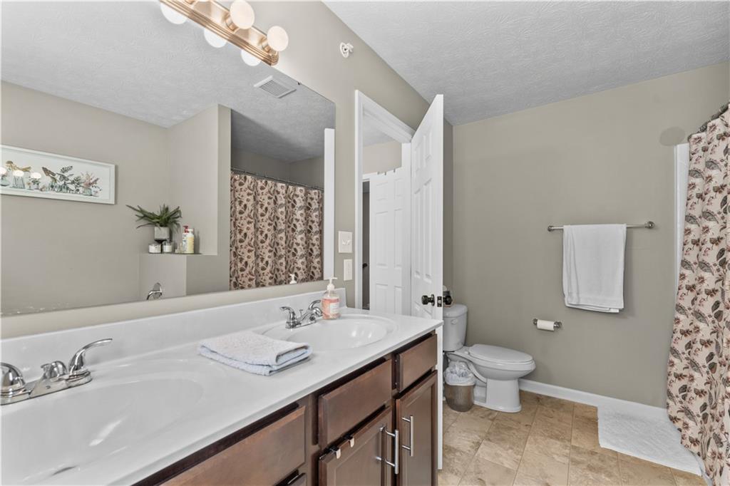 159 Rylie Drive Harmony, PA 16037 - Photo 27 of 36 a bathroom with a granite countertop sink a toilet and a mirror
