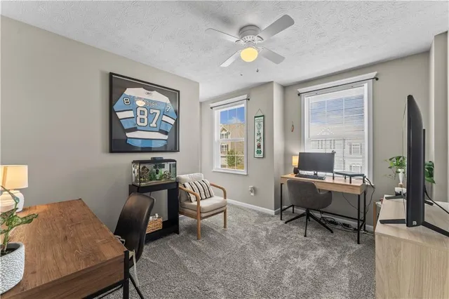 a view of a workspace with furniture and a window