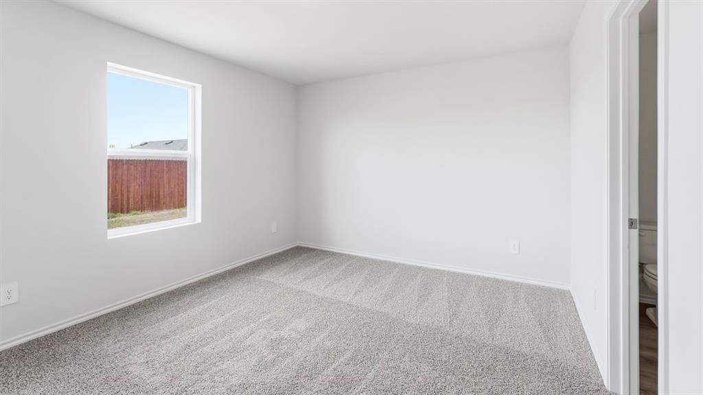 3319 Twilight Trail Forney, TX 75126 - Photo 13 of 33 Bright interior space featuring a window with a white frame, light gray carpet, white walls, and white baseboards