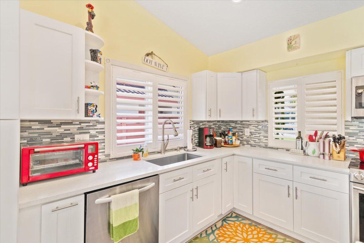 a kitchen with stainless steel appliances cabinets and a window