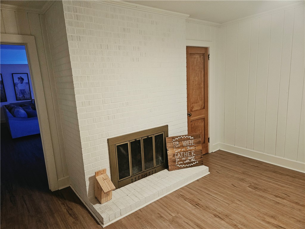 757 Belle Shoals Road Pickens, SC 29671 - Photo 31 of 31 Warm wood-look flooring complements the white brick fireplace and traditional wooden door.