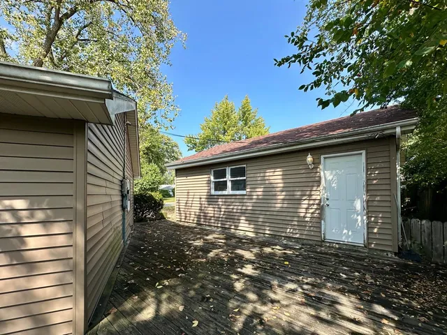 a backyard of a house with large tree and wooden fence