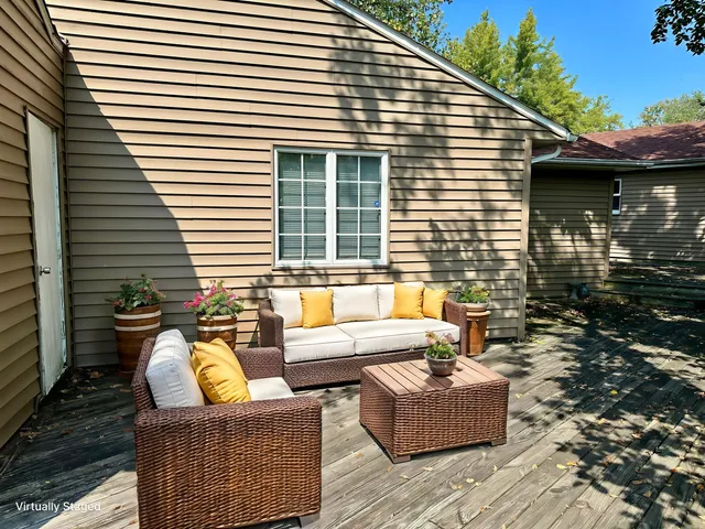 a view of a patio with couches chairs and wooden floor