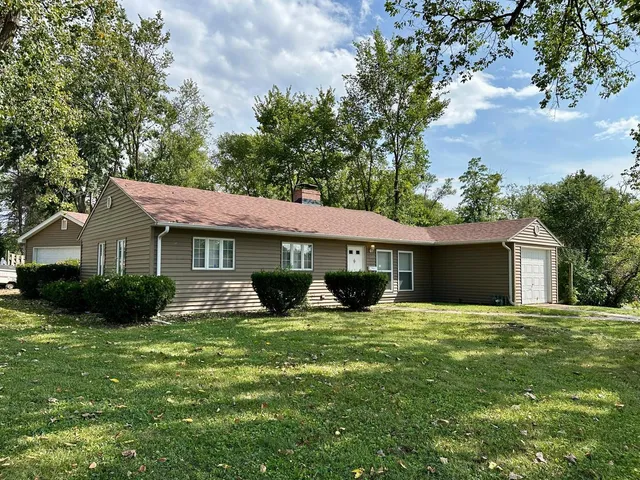 a view of a house with a yard and tree