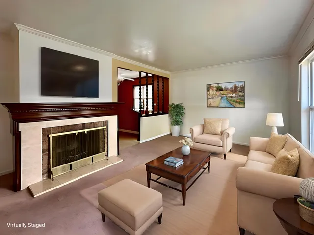 a living room with furniture a flat screen tv and a fireplace
