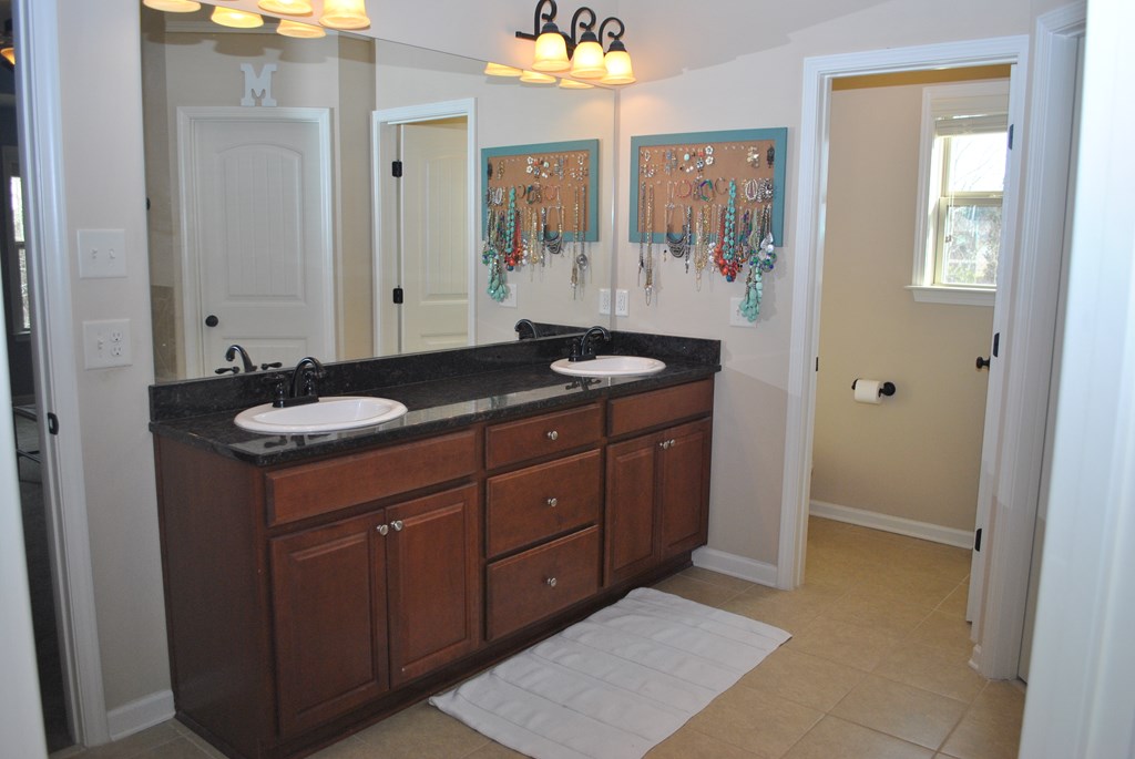 9536 English Ivy Court Fortson, GA 31808 - Photo 14 of 22 a bathroom with a granite countertop sink a mirror and a shower