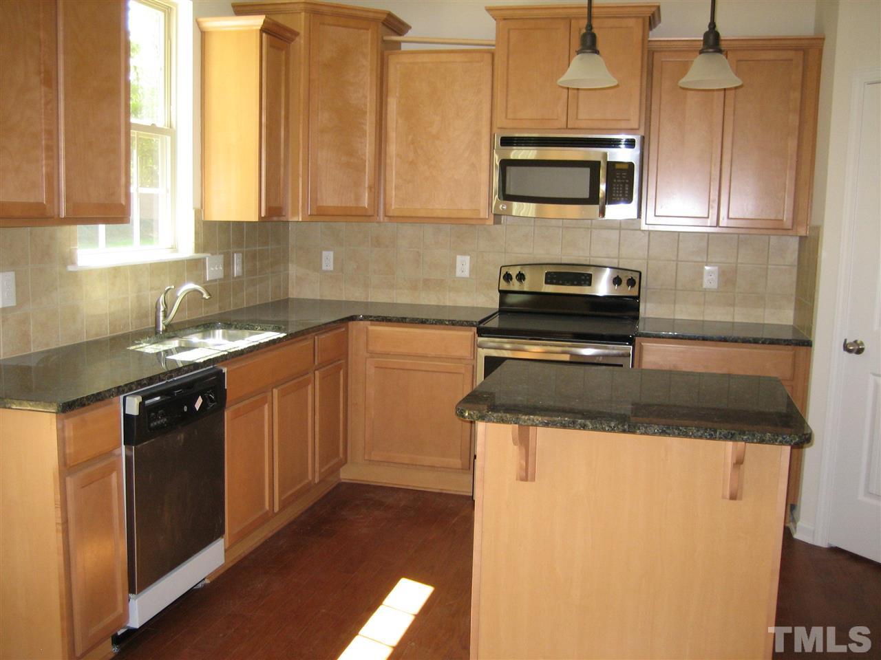 2436 Everstone Road Wake Forest, NC 27587 - Photo 8 of 25 Kitchen -Birch cabinets with High-Low layout included trim at top of cabinets. Small Island with 2 pendants, Walk-In corner Pantry