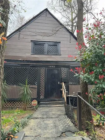 a tall house with trees in front of it