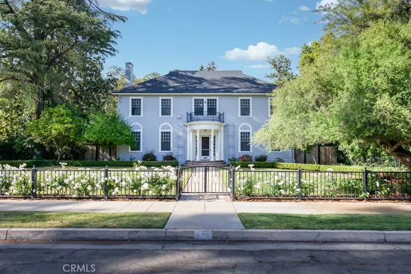 a front view of a house with a yard and potted plants
