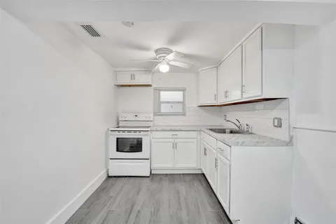 a kitchen with granite countertop white cabinets and white appliances