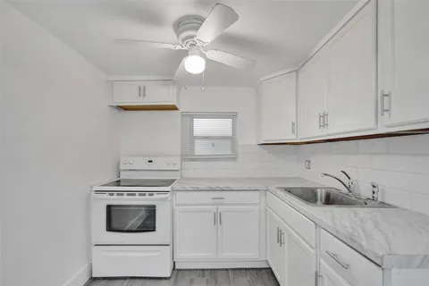 a kitchen with white cabinets stainless steel appliances and sink