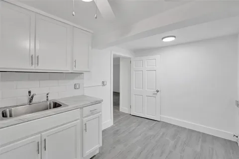 a kitchen with white cabinets and sink