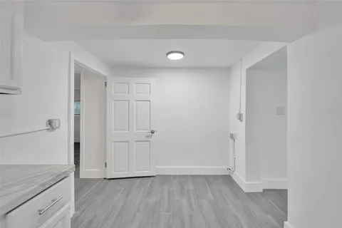 a view of an empty room with closet and wooden floor