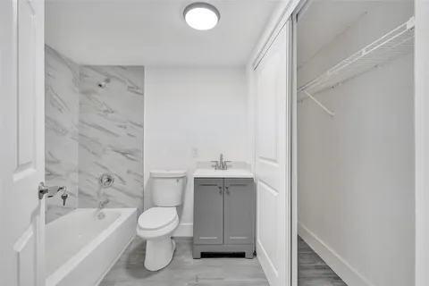 a bathroom with a granite countertop sink toilet and bathtub