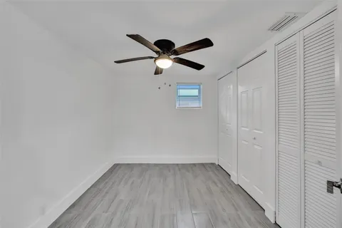a view of room with hardwood floor and a ceiling fan