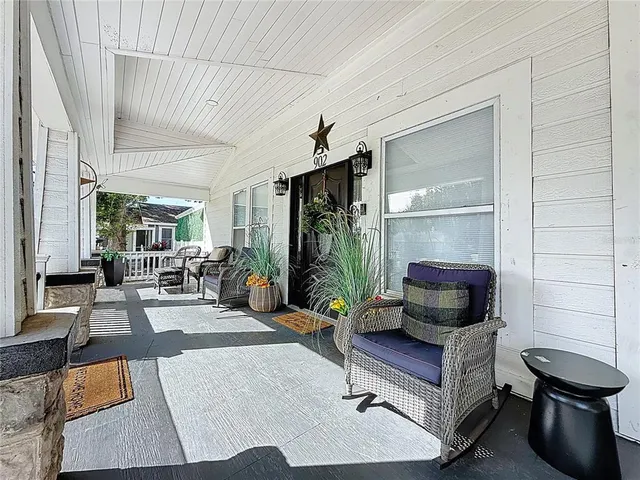 a living room with furniture wooden floor and a large window