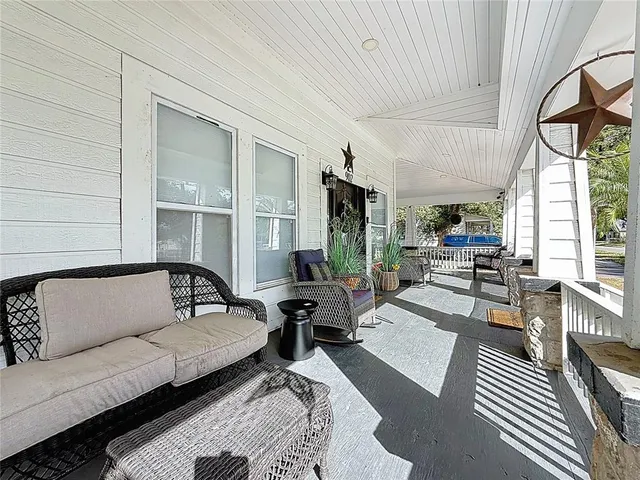 a living room with furniture a rug and a bookshelf