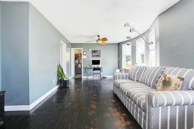 a living room with furniture and a wooden floor