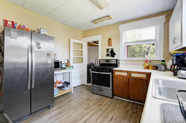 a kitchen with granite countertop a refrigerator stove and sink
