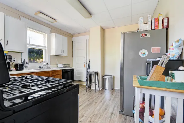 a kitchen with stainless steel appliances granite countertop a stove top oven a sink dishwasher and cabinets with wooden floor