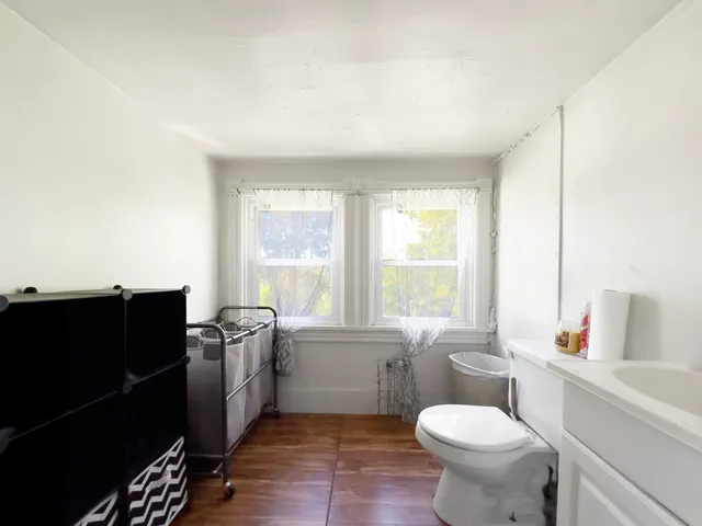 a bathroom with a sink toilet and window