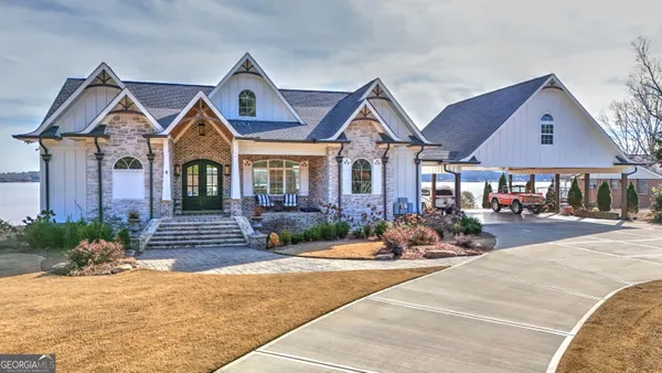a front view of a house with yard and parking