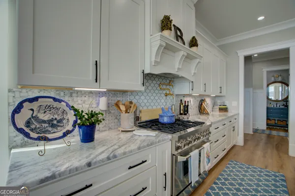 a kitchen with stainless steel appliances granite countertop a sink a stove and a wooden floors