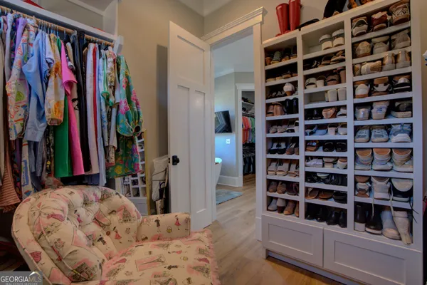 a view of walk in closet with clothes and shoes