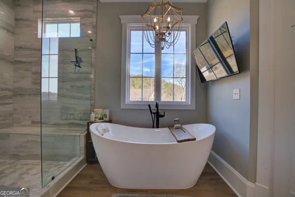 a white bath tub sitting in a bathroom next to a window