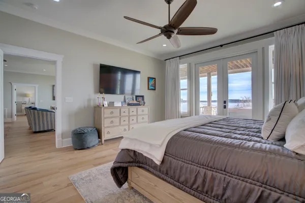 a bedroom with a bed a couch and a flat screen tv