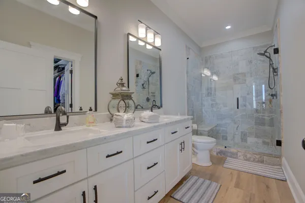a bathroom with a double vanity sink toilet and shower