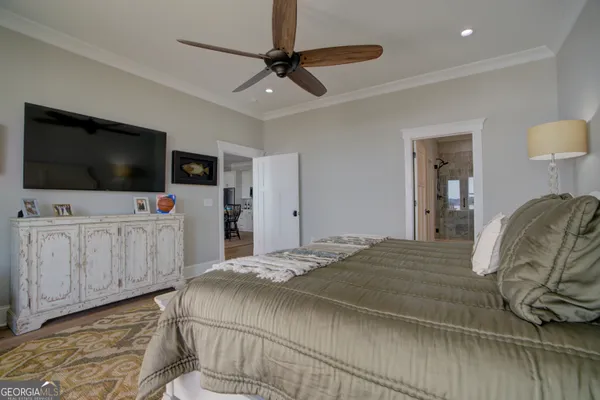a bedroom with a bed and a flat tv screen on dresser