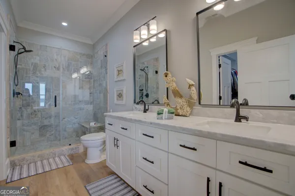 a bathroom with a double vanity sink toilet and shower