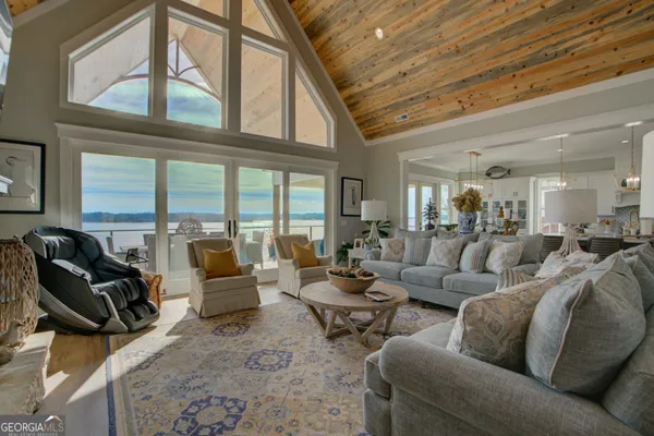 a living room with furniture fireplace and large windows