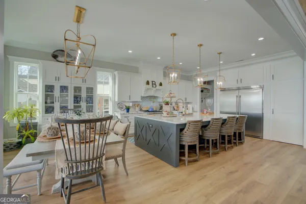 a dining room with a table chairs and kitchen view