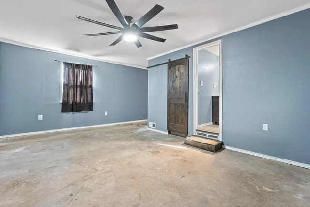 an empty room with windows and fan